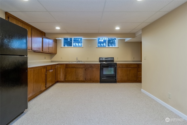 kitchen featuring black appliances, a paneled ceiling, sink, and light carpet