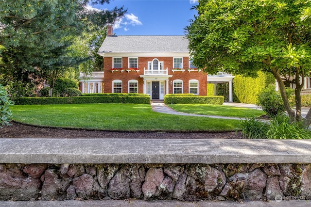 colonial inspired home featuring a front lawn