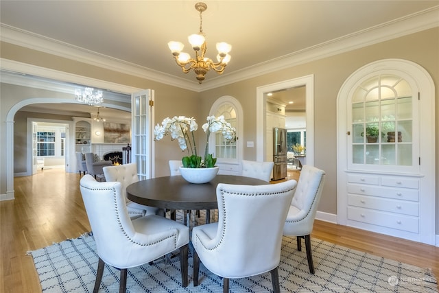 dining space with hardwood / wood-style floors, a notable chandelier, and ornamental molding