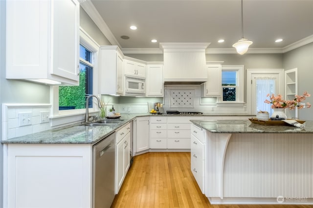 kitchen featuring hanging light fixtures, sink, white cabinets, and stainless steel appliances