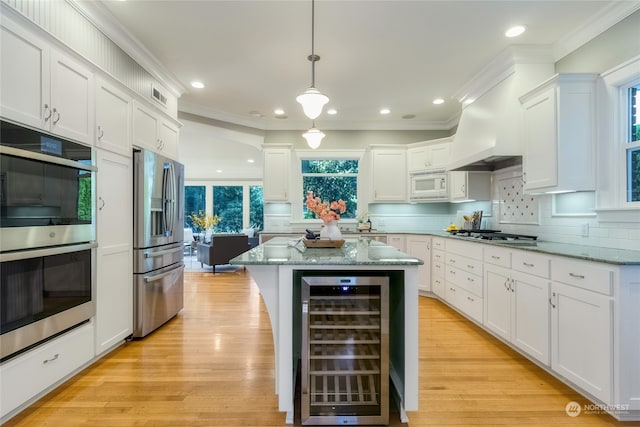 kitchen with plenty of natural light, white cabinetry, stainless steel appliances, and wine cooler