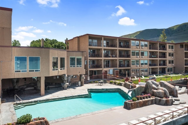 view of swimming pool with a mountain view and pool water feature