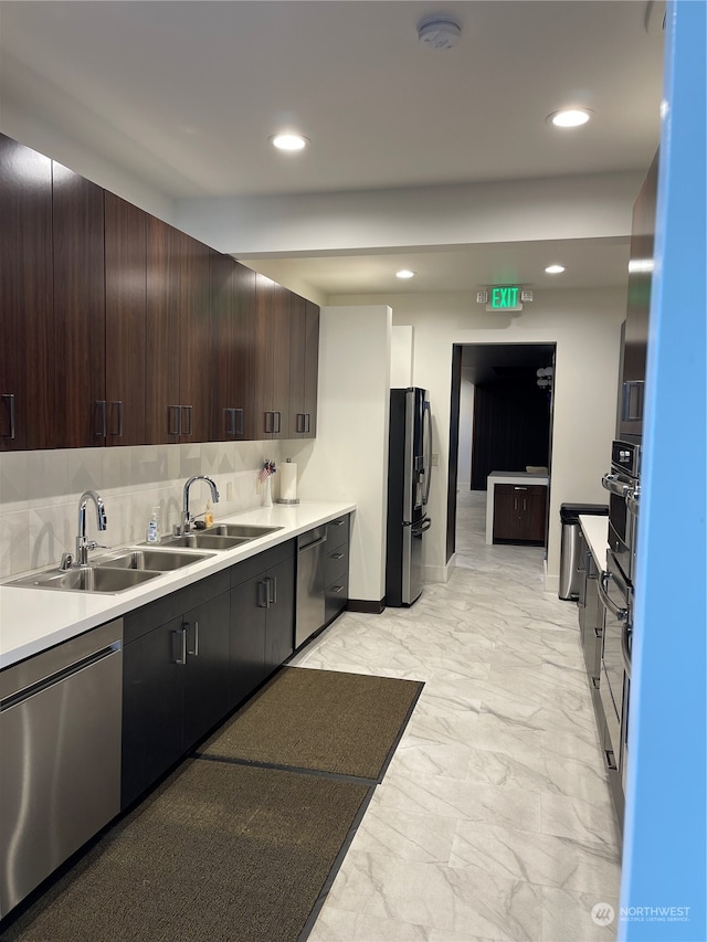 kitchen featuring tasteful backsplash, dark brown cabinetry, sink, and stainless steel appliances