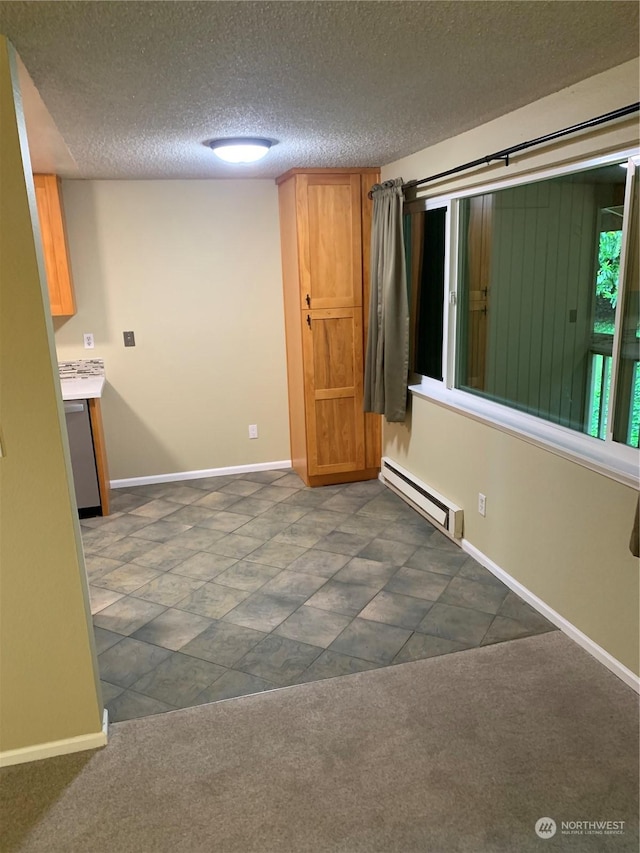 empty room with dark colored carpet, a textured ceiling, and a baseboard radiator