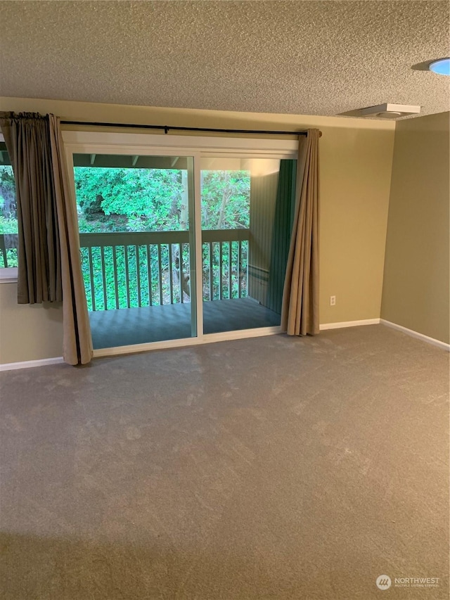 carpeted spare room with a textured ceiling