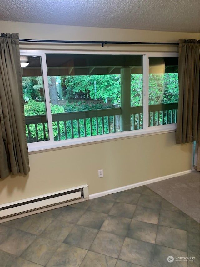 spare room featuring a baseboard radiator and a textured ceiling