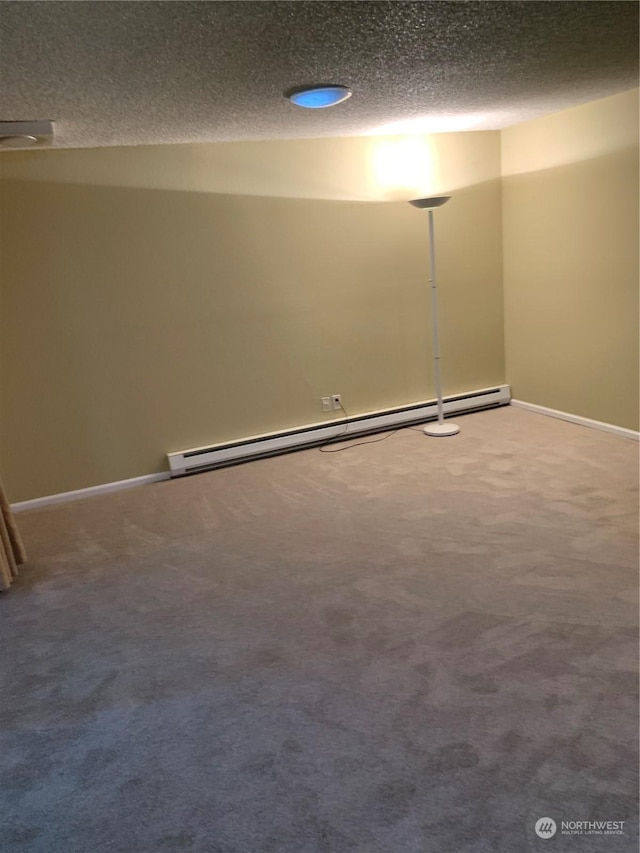 carpeted empty room featuring a textured ceiling and a baseboard heating unit