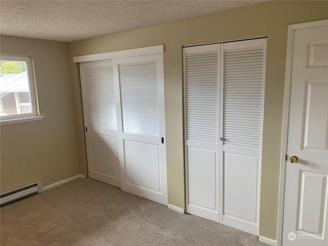 14150 SE 17th Pl Unit B-8, Bellevue, WA 98007 - unfurnished bedroom featuring light carpet, a baseboard radiator, a textured ceiling, and two closets