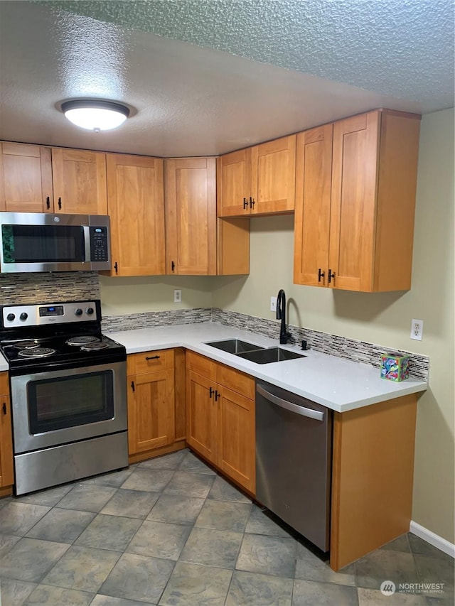 kitchen with sink, stainless steel appliances, and a textured ceiling