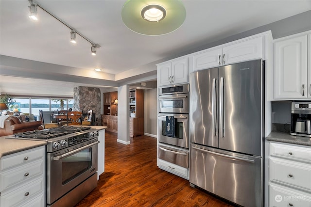 kitchen with white cabinets, stainless steel appliances, and dark wood-type flooring