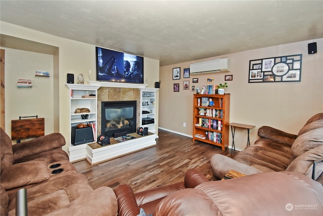 living room with a tile fireplace, hardwood / wood-style floors, and an AC wall unit