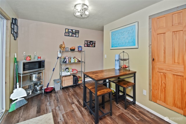 dining space with dark hardwood / wood-style flooring