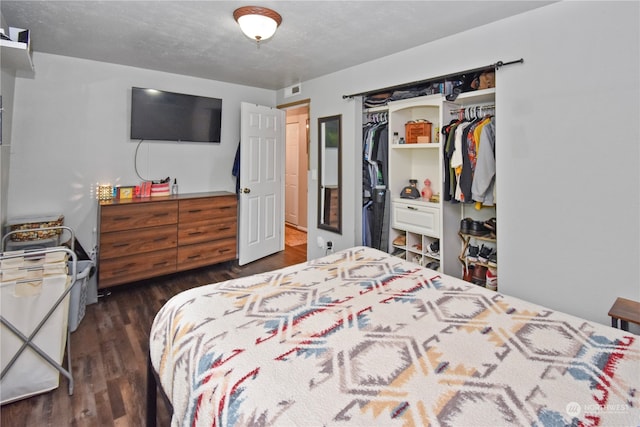 bedroom featuring a textured ceiling, a closet, and dark wood-type flooring