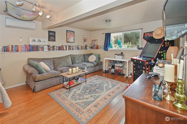 living room featuring hardwood / wood-style flooring, rail lighting, and a wall unit AC