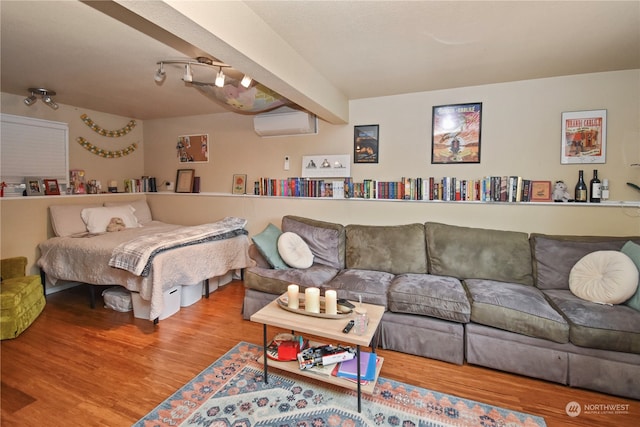 bedroom featuring beamed ceiling, wood-type flooring, and an AC wall unit