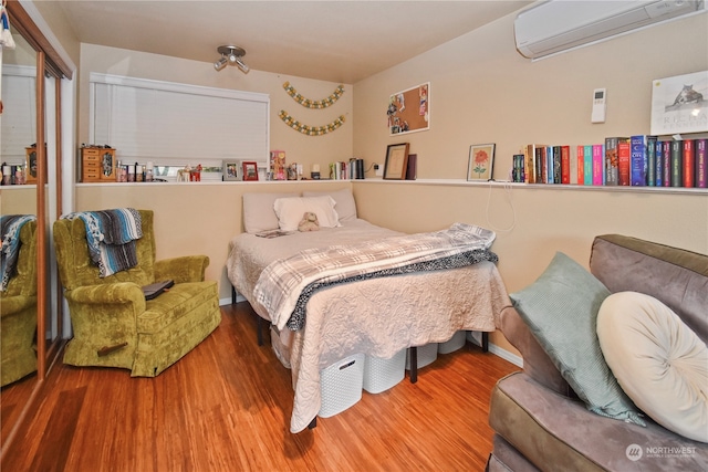 bedroom with wood-type flooring and a wall mounted air conditioner