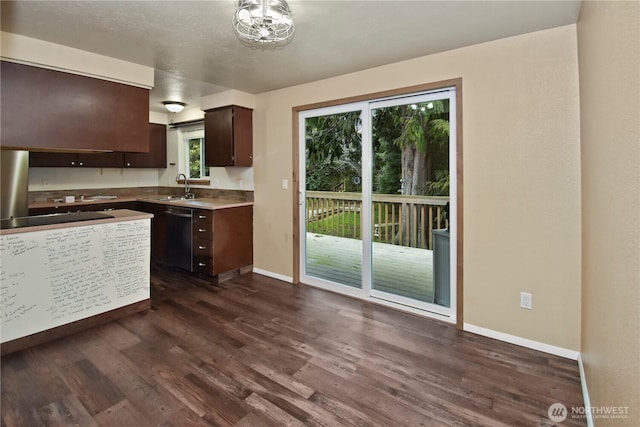 kitchen with light countertops, dark wood-type flooring, a sink, dark brown cabinets, and black appliances