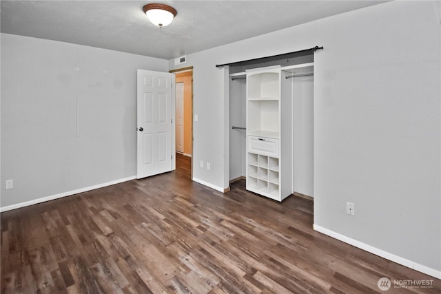 unfurnished bedroom featuring visible vents, baseboards, and dark wood finished floors