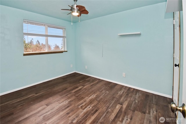 spare room with a ceiling fan, dark wood finished floors, and baseboards