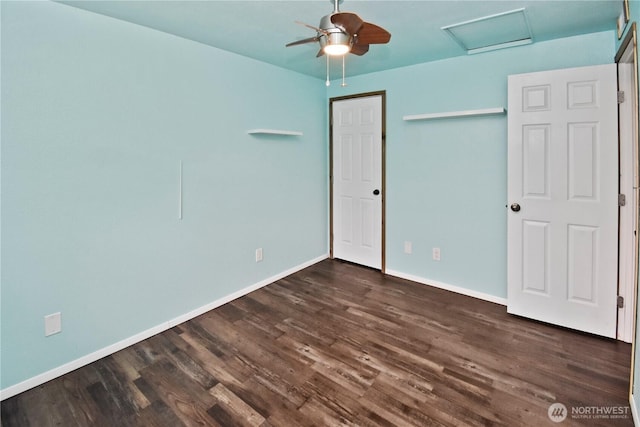 unfurnished bedroom featuring a closet, dark wood finished floors, attic access, and baseboards