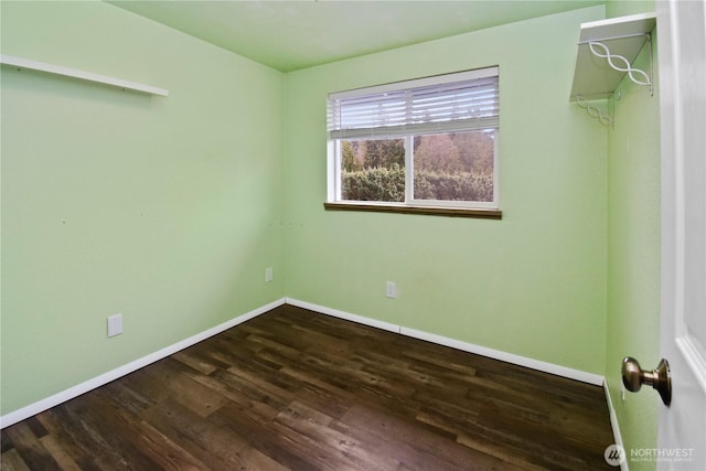 unfurnished room featuring dark wood-style flooring and baseboards