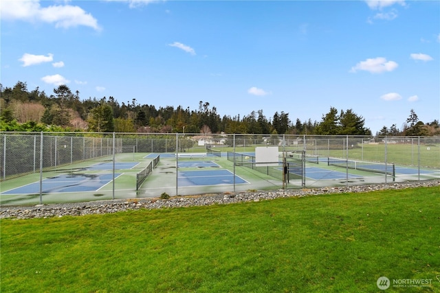 view of sport court with a yard and fence