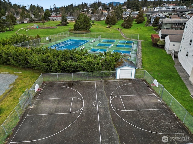 view of sport court featuring community basketball court, a residential view, and a lawn