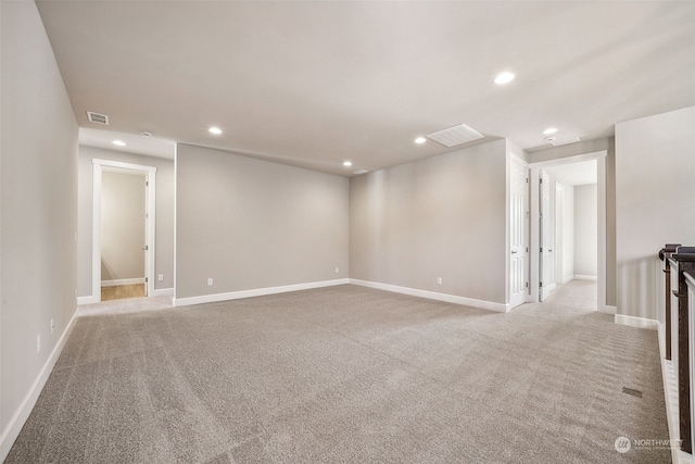 spare room with recessed lighting, visible vents, light carpet, and baseboards