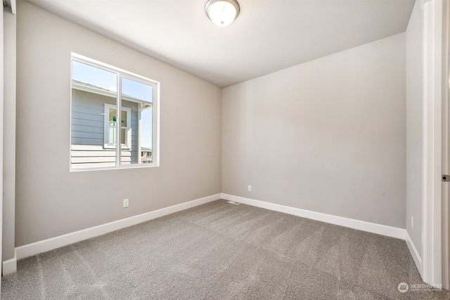 empty room featuring carpet flooring and baseboards