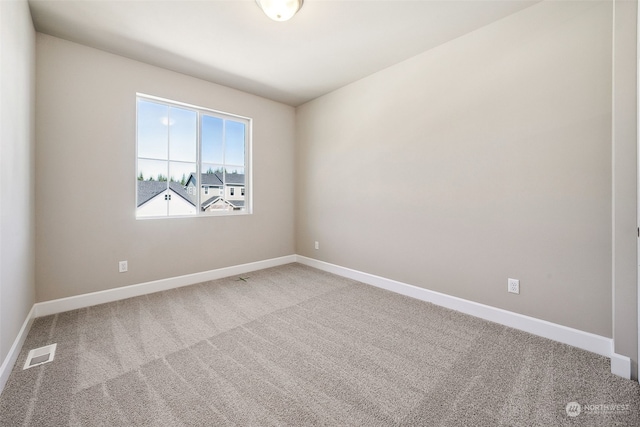 carpeted spare room featuring visible vents and baseboards