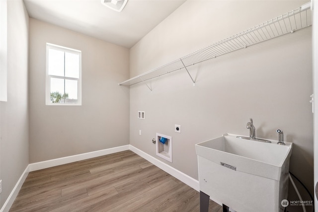 laundry area with hookup for a washing machine, light wood-style flooring, laundry area, a sink, and electric dryer hookup