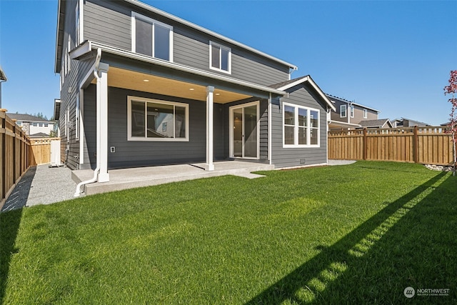 back of property featuring a fenced backyard, a patio, and a lawn