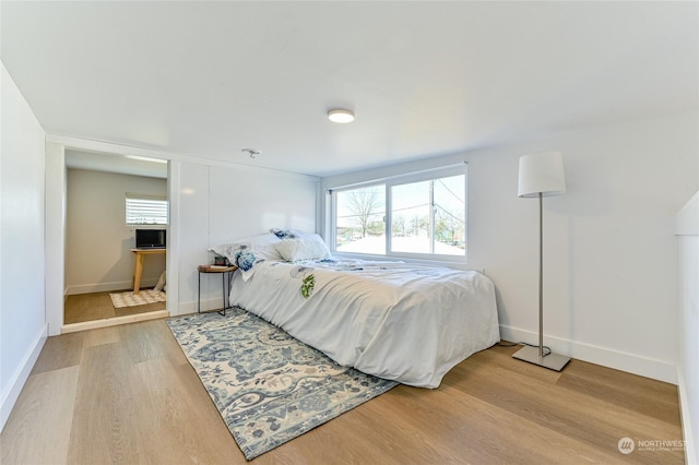 bedroom featuring baseboards and wood finished floors