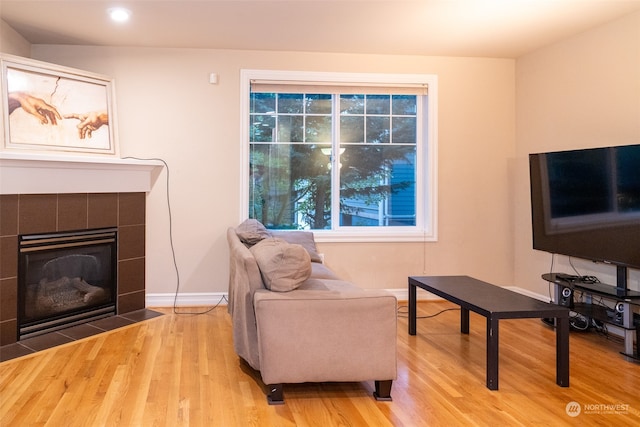 interior space with a tiled fireplace and light hardwood / wood-style flooring