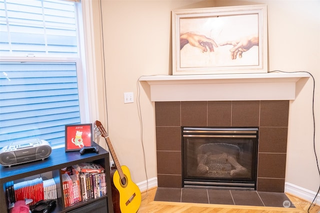 room details with hardwood / wood-style flooring and a tiled fireplace