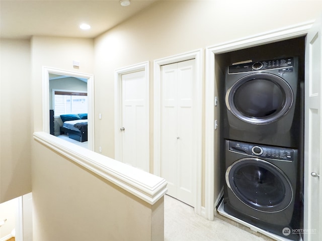 washroom featuring stacked washer and clothes dryer and light colored carpet