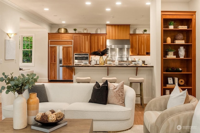 living room with light wood-type flooring and crown molding