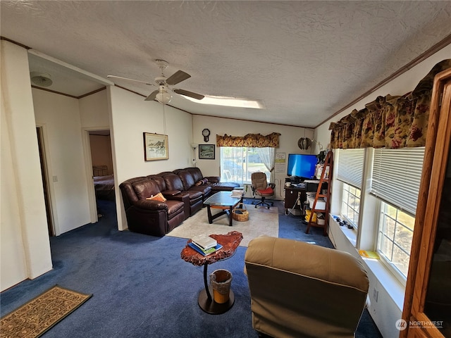 living room with ceiling fan, a textured ceiling, dark carpet, and ornamental molding