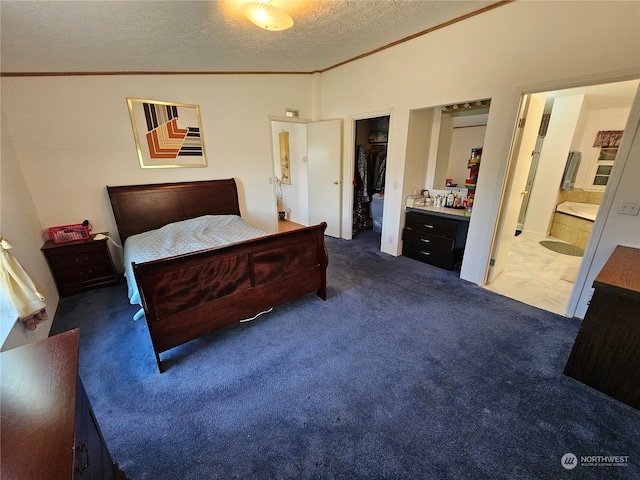 bedroom with vaulted ceiling, ornamental molding, connected bathroom, dark colored carpet, and a textured ceiling