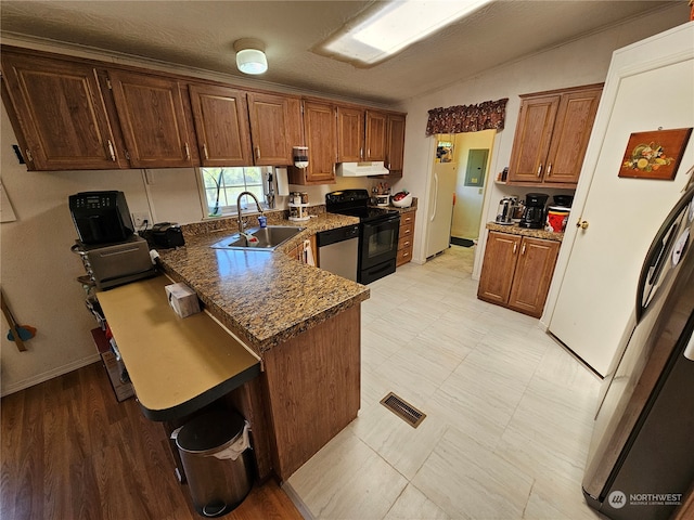 kitchen with stainless steel dishwasher, dark stone countertops, light tile floors, sink, and black range with electric stovetop