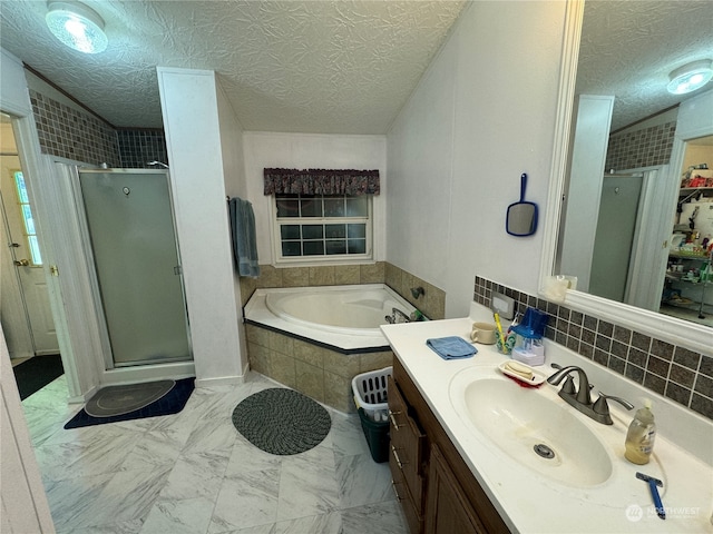 bathroom featuring backsplash, vanity with extensive cabinet space, tile flooring, independent shower and bath, and a textured ceiling