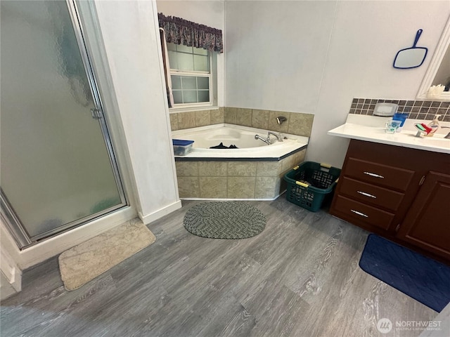 12 Moonlight Dr, Oroville, WA 98844 - full bath featuring a shower stall, wood finished floors, a garden tub, vanity, and decorative backsplash