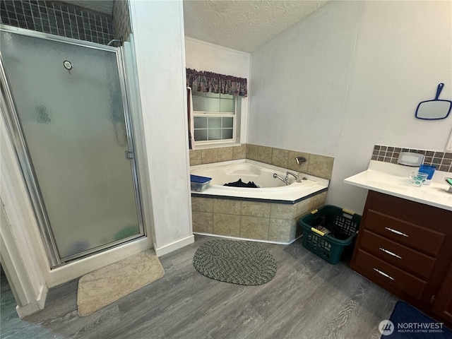 12 Moonlight Dr, Oroville, WA 98844 - bathroom with wood finished floors, a bath, a shower stall, a textured ceiling, and vanity