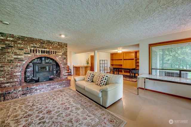 living room with carpet, a textured ceiling, a wood stove, and brick wall