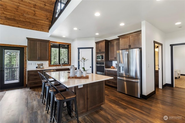 kitchen with dark hardwood / wood-style flooring, a center island, stainless steel appliances, and sink