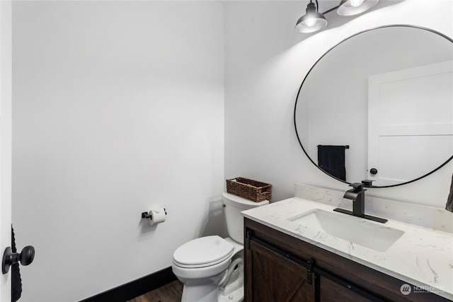 bathroom with vanity, hardwood / wood-style flooring, and toilet