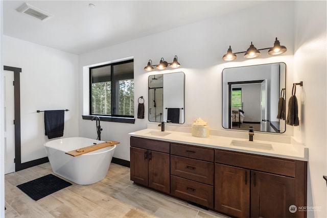 bathroom featuring a bath, vanity, and wood-type flooring