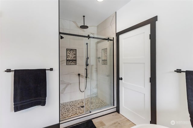 bathroom with hardwood / wood-style floors and an enclosed shower