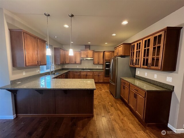 8701 29th Way SE, Olympia, WA 98513 - kitchen featuring kitchen peninsula, stainless steel appliances, sink, decorative light fixtures, and hardwood / wood-style floors