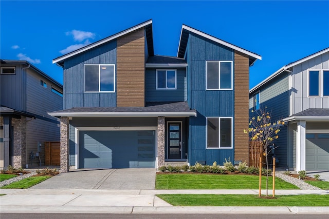 contemporary house featuring a garage and a front lawn